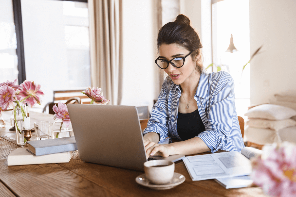 Uma jovem trabalhando de casa em um notebook, ilustrando a evolução das microtarefas globais e a liberdade do trabalho digital remoto via plataformas descentralizadas.