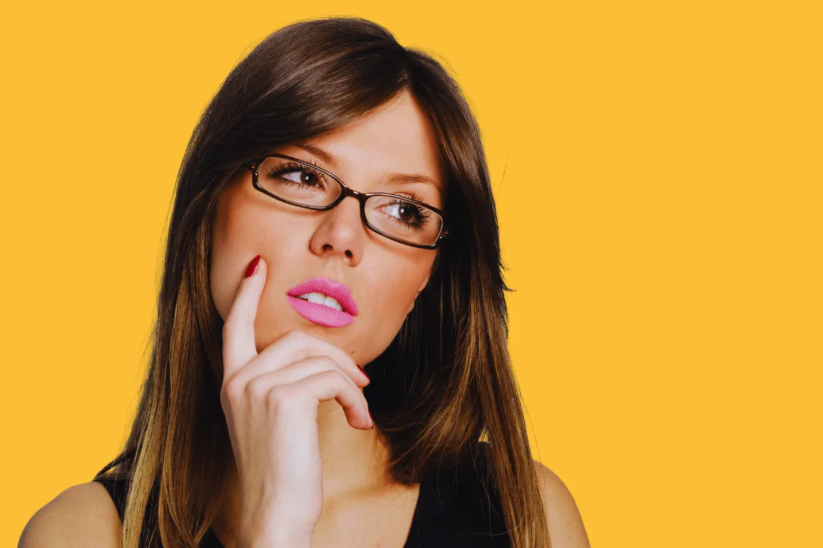 Mulher pensativa com a mão no queixo, representando as dúvidas comuns sobre o que é JumpTask e se vale a pena usar essa plataforma de renda extra.