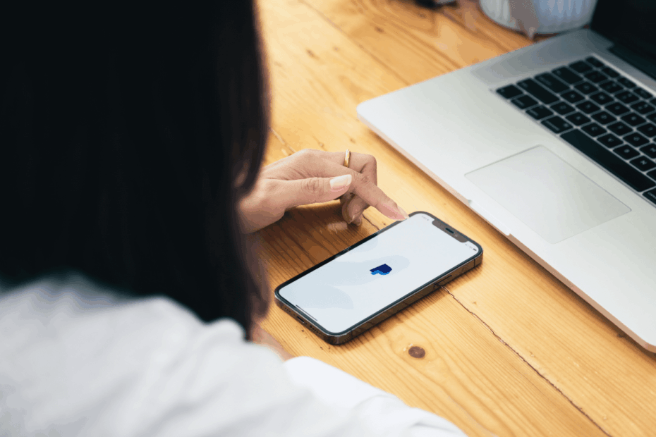 Pessoa conferindo o aplicativo do PayPal no celular para verificar o recebimento do saque mínimo do Ysense.