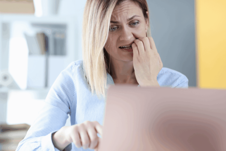 Mulher preocupada olhando para o notebook, representando as dúvidas e desafios sobre se é lucrativo trabalhar como afiliado no mercado digital atual.