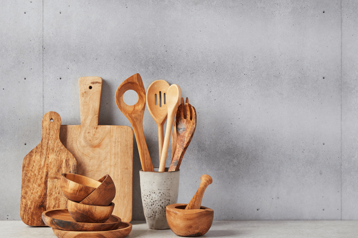 Conjunto de utensílios de cozinha e tábuas de madeira representando a escolha estratégica de um nicho lucrativo, como Casa e Decoração, no programa de afiliados do Mercado Livre.