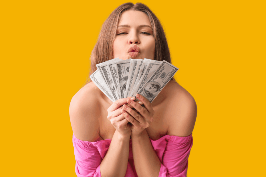 Mulher feliz segurando um leque de notas de dólar sobre fundo amarelo, simbolizando os lucros e a renda extra obtida nos melhores sites para ganhar dinheiro respondendo pesquisas online.
