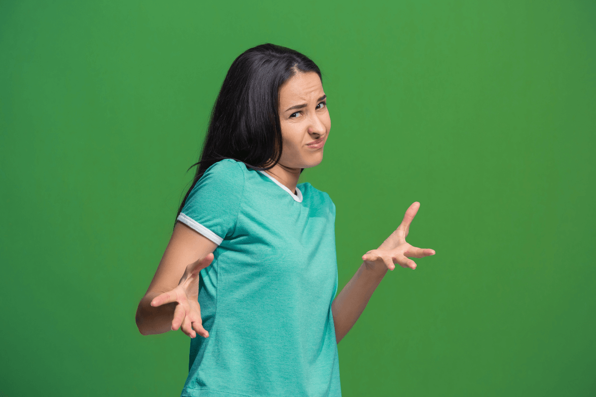 Mulher jovem com expressão de dúvida e mãos levantadas, ilustrando a pergunta frequente: Posso comprar no meu próprio link de afiliado Mercado Livre?