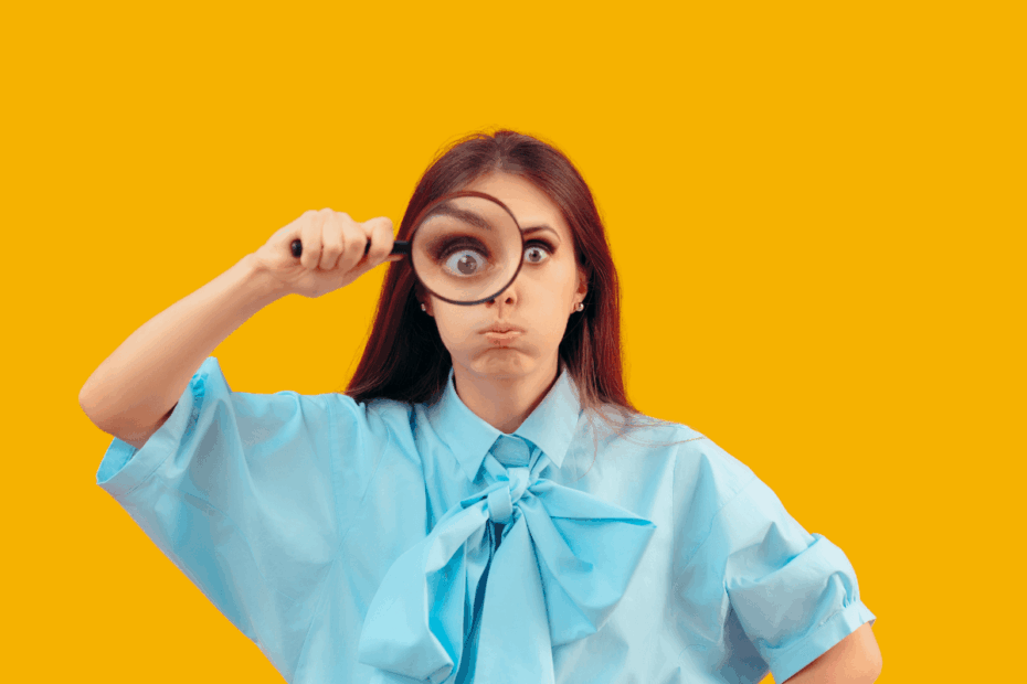 Mulher com lupa investigando quais lojas aceitam afiliados e pagam as melhores comissões no varejo.